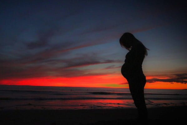 Mujer embarazada, playa, atardecer, cabizbaja, triste