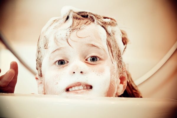 Trastornos, madurez, capacidades y desarrollo. Se ve a una niña asomando por su bañera llena de espuma